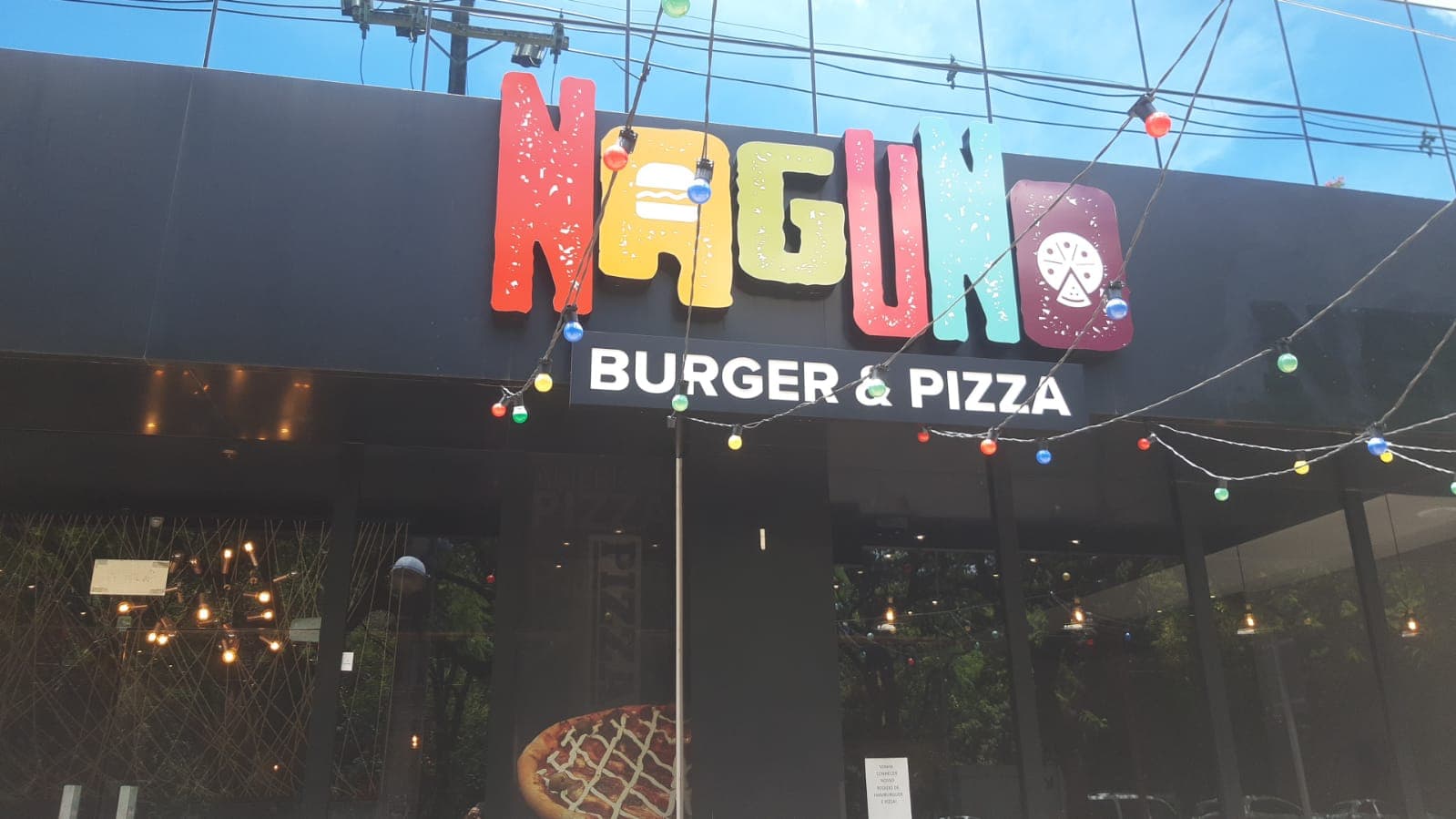Fachada iluminada do restaurante Nagumo Burger & Pizza, cliente da Insectus